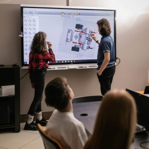 Teens engaged in robotics teamwork in a modern classroom setting.